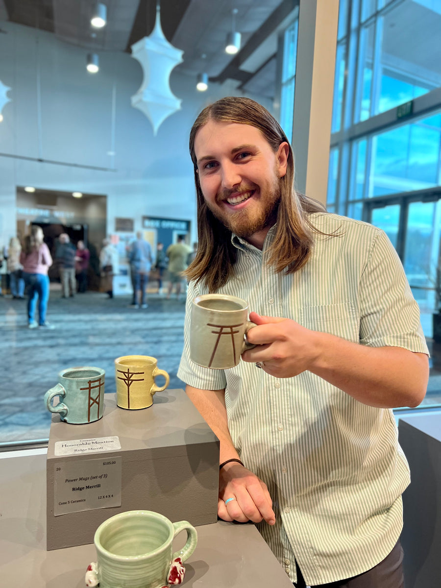 Ridge showing his awarding winning "Power Mugs" at the Sears Art Museum